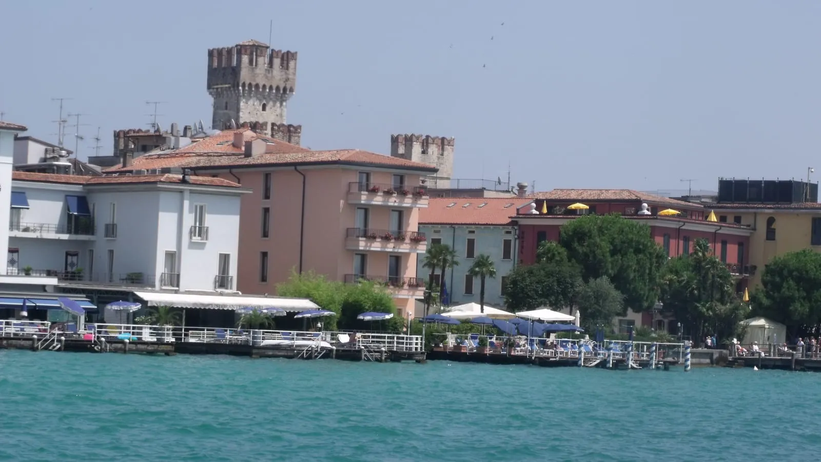 Sirmione waterfront and the Scaliger Castle tower seen from Lake Garda, first stop of the private day tour from Milan